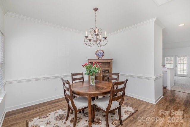 dining space featuring a notable chandelier, dark hardwood / wood-style flooring, and ornamental molding