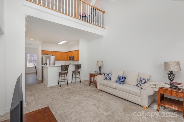 carpeted living room featuring a high ceiling