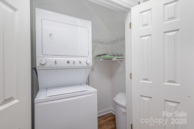 washroom featuring dark hardwood / wood-style floors and stacked washer / drying machine