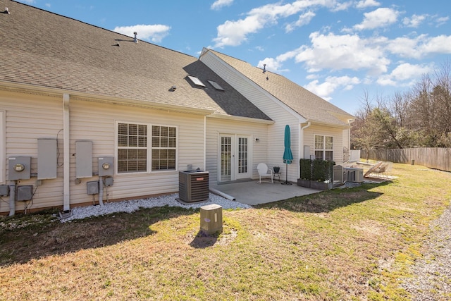 rear view of house with central AC unit, a yard, french doors, and a patio area