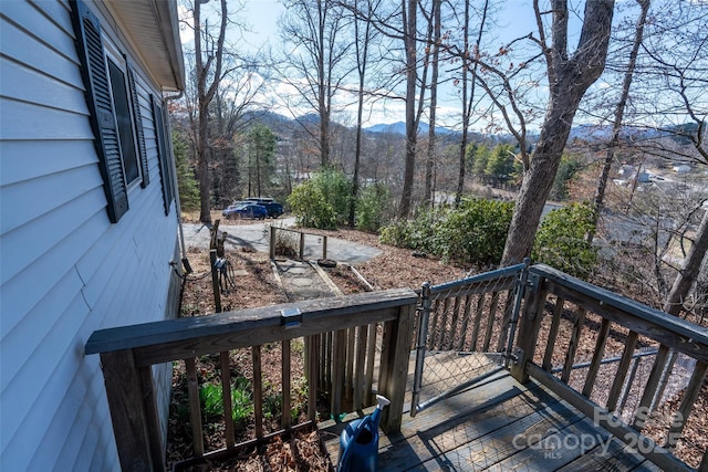 wooden terrace with a forest view and a mountain view