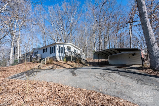 view of side of property featuring driveway and a detached carport