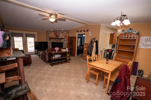 dining room with a fireplace, visible vents, light carpet, a textured ceiling, and ceiling fan with notable chandelier