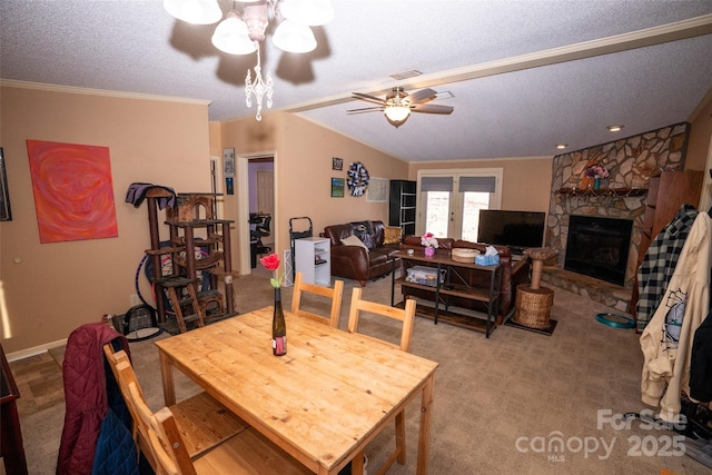 carpeted dining area with a fireplace, crown molding, a ceiling fan, vaulted ceiling, and a textured ceiling