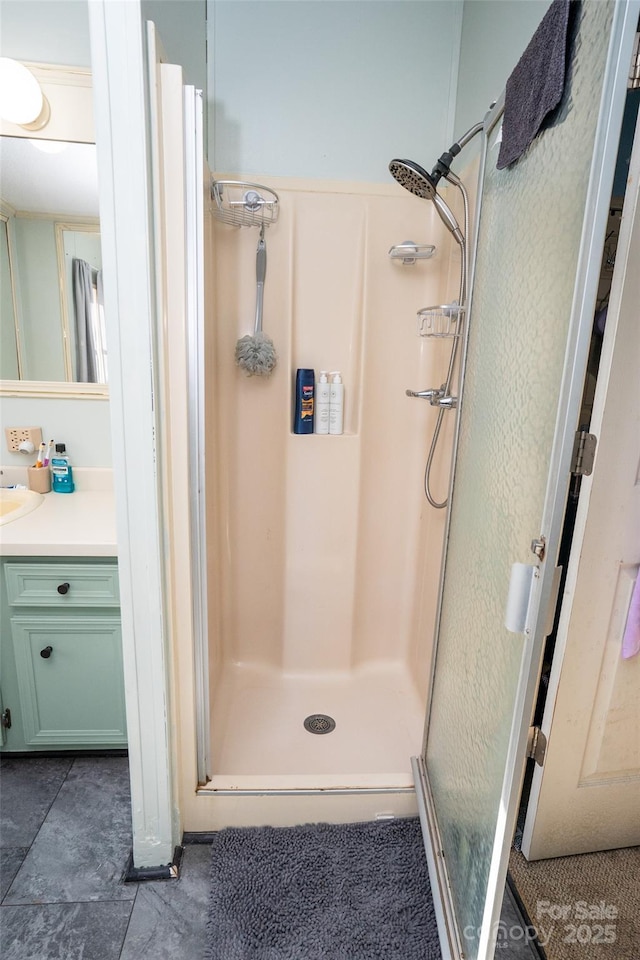 bathroom with a shower stall and vanity