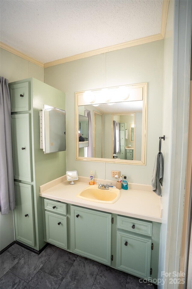 bathroom with crown molding, vanity, and a textured ceiling