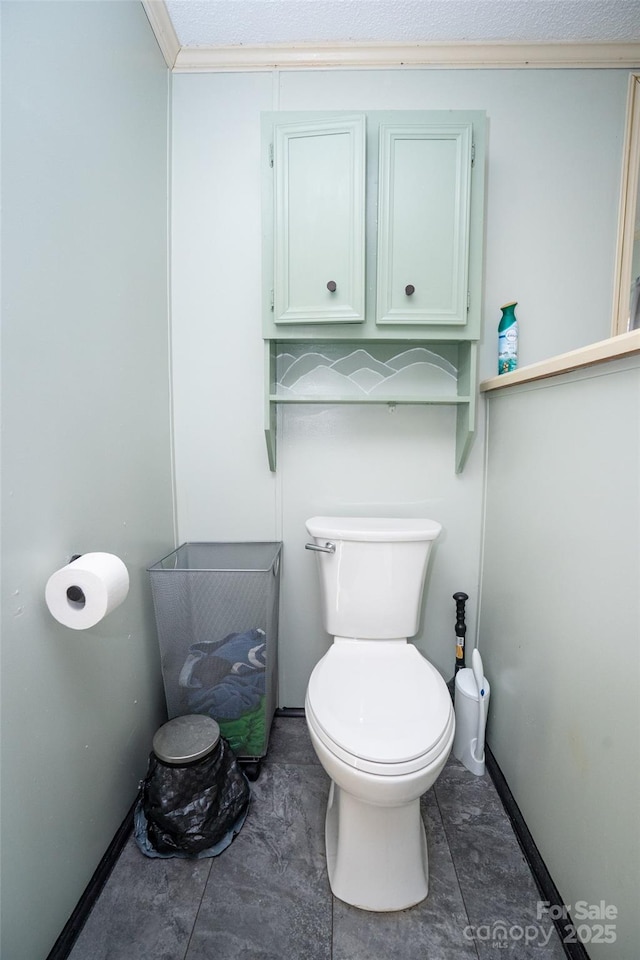 bathroom featuring toilet and baseboards