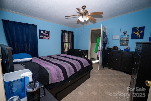 carpeted bedroom with ornamental molding, ceiling fan, and a textured ceiling