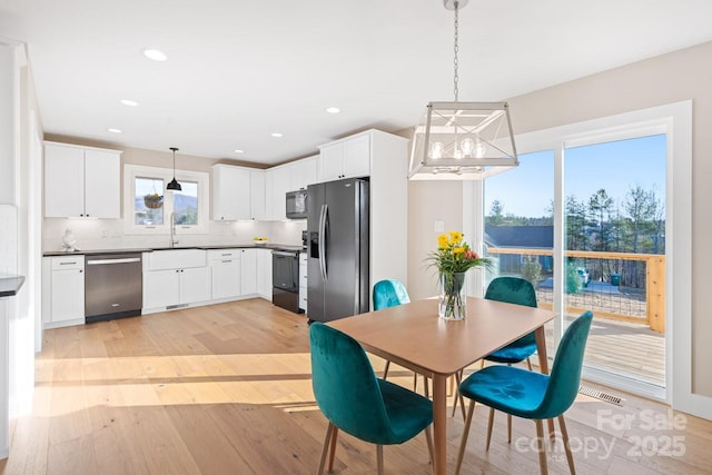 dining area featuring light wood finished floors and recessed lighting