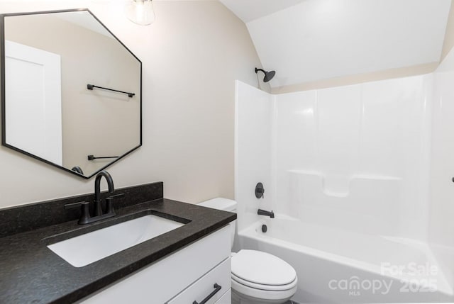 full bathroom featuring lofted ceiling, bathing tub / shower combination, vanity, and toilet