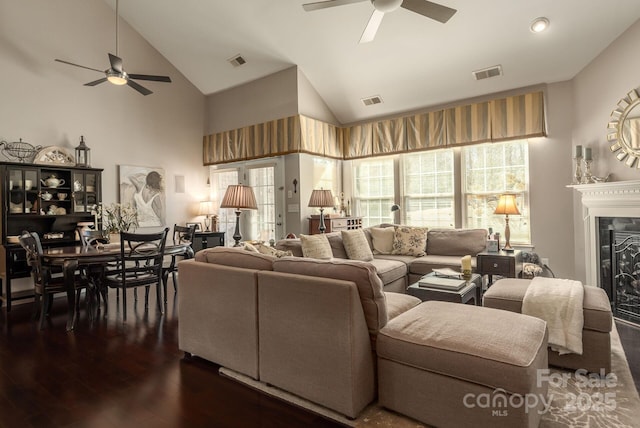 living room with ceiling fan, dark hardwood / wood-style flooring, and high vaulted ceiling