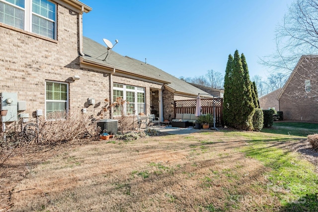 back of property with a yard, outdoor lounge area, a patio, and central air condition unit