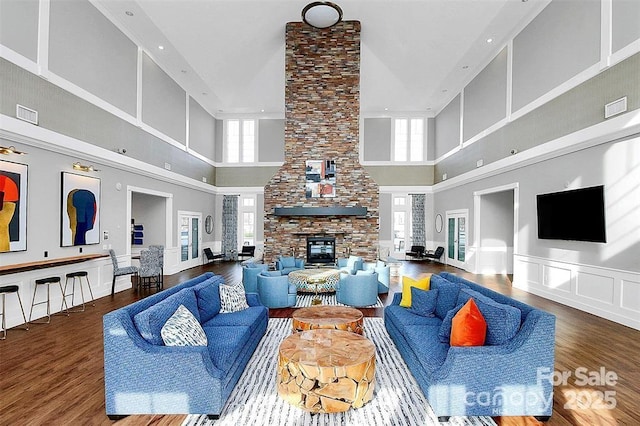 living room featuring a healthy amount of sunlight, a fireplace, and wood-type flooring