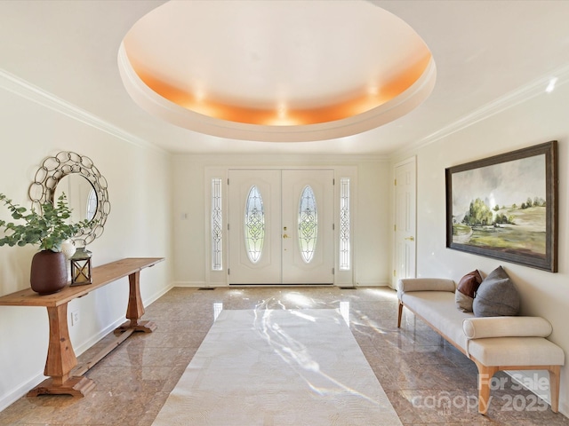 foyer entrance with crown molding and a raised ceiling