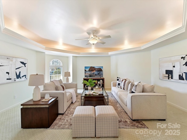 living room featuring crown molding, ceiling fan, a raised ceiling, and light carpet