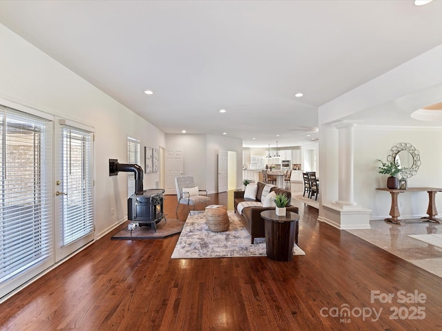 living room featuring decorative columns and dark wood-type flooring