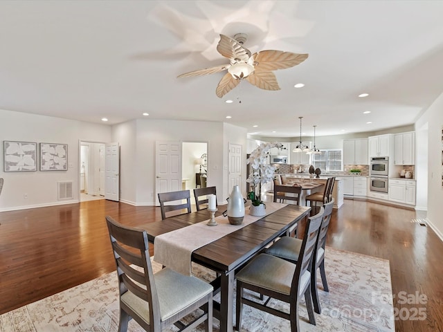 dining area with ceiling fan and dark hardwood / wood-style flooring