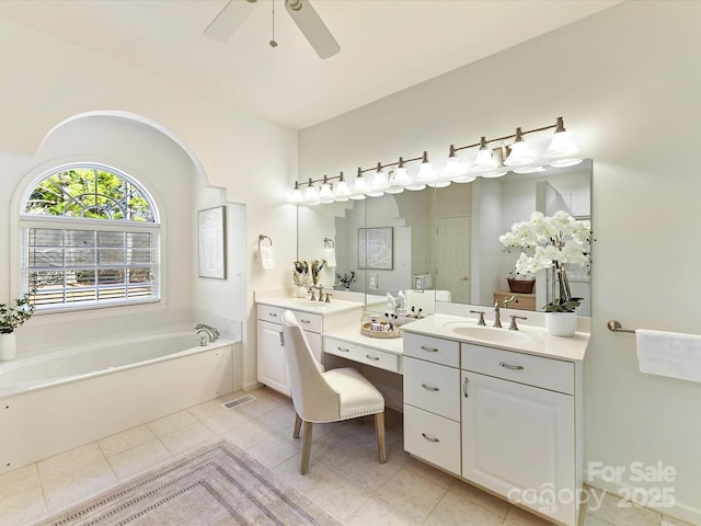 bathroom featuring ceiling fan, tile patterned floors, vanity, and a bathing tub