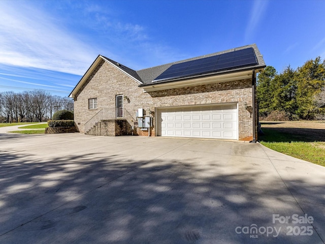 view of side of property featuring a garage and solar panels