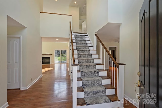 entryway featuring hardwood / wood-style flooring and a towering ceiling