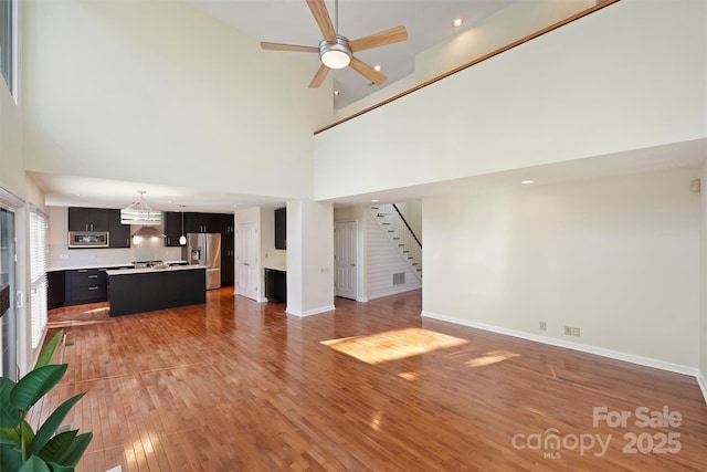 unfurnished living room featuring hardwood / wood-style floors and ceiling fan