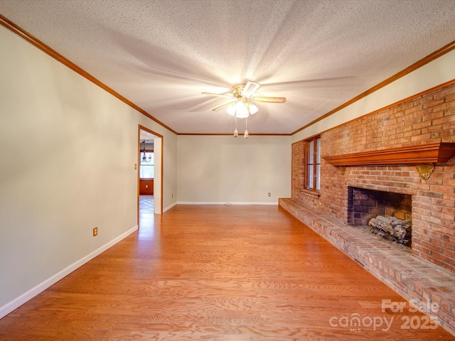 unfurnished living room with ornamental molding, a textured ceiling, a brick fireplace, and light wood-type flooring