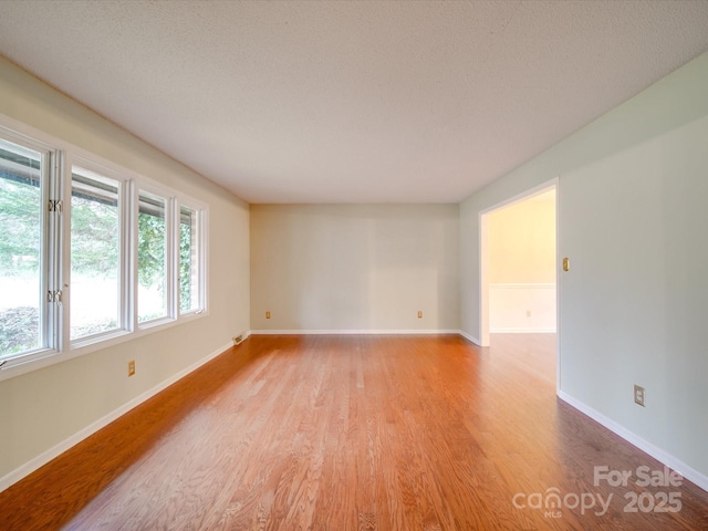 empty room featuring a textured ceiling and light wood-type flooring