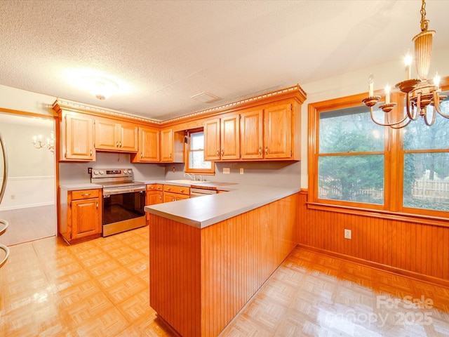 kitchen with an inviting chandelier, stainless steel electric range oven, a textured ceiling, kitchen peninsula, and pendant lighting