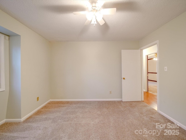 unfurnished room with ceiling fan, light colored carpet, and a textured ceiling