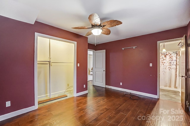 unfurnished bedroom featuring hardwood / wood-style flooring, ceiling fan, connected bathroom, and a closet