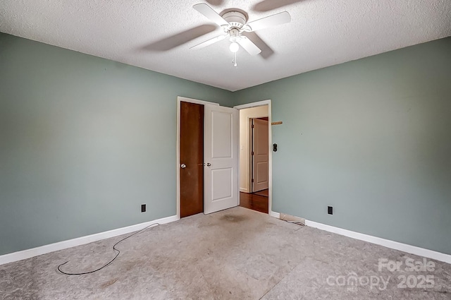 spare room featuring ceiling fan, carpet, and a textured ceiling