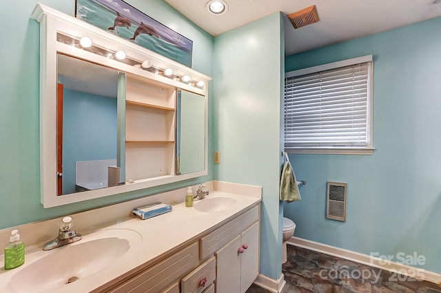 bathroom with vanity, toilet, and heating unit