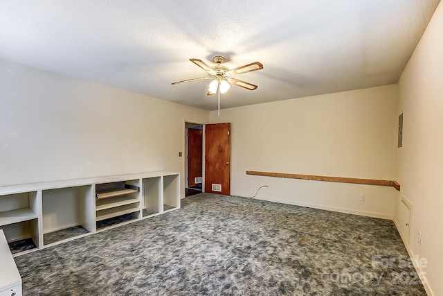 carpeted spare room with a textured ceiling, electric panel, and ceiling fan