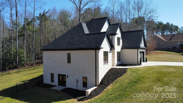 view of side of property featuring brick siding, a yard, and roof with shingles