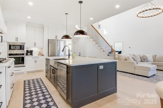 kitchen with light countertops, an island with sink, and white cabinetry