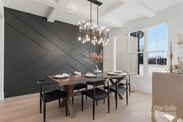 dining room with light wood-style flooring, coffered ceiling, and beamed ceiling