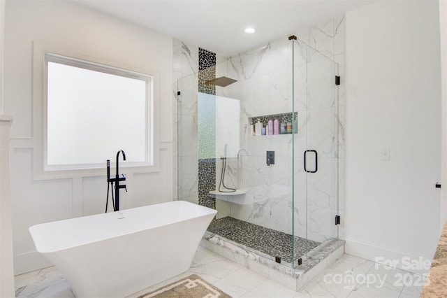 bathroom with a marble finish shower, marble finish floor, a freestanding bath, a decorative wall, and recessed lighting