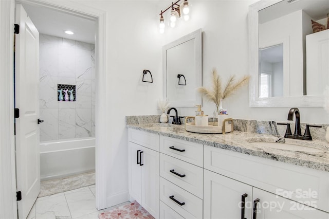 bathroom featuring marble finish floor, double vanity, and a sink