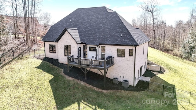 rear view of property with brick siding, a fenced backyard, and a yard