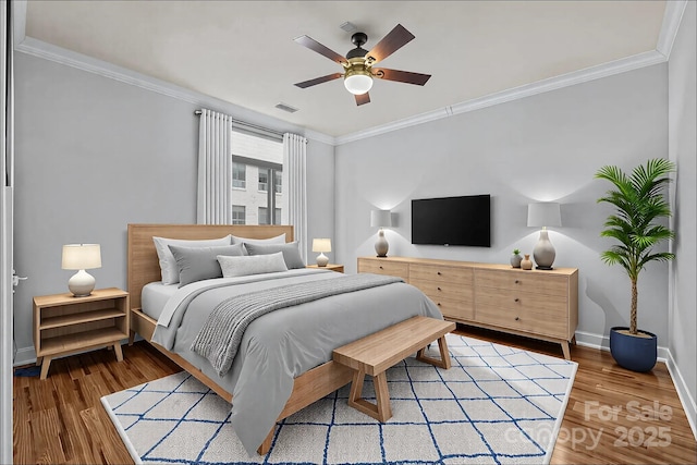 bedroom featuring visible vents, baseboards, ornamental molding, wood finished floors, and a ceiling fan