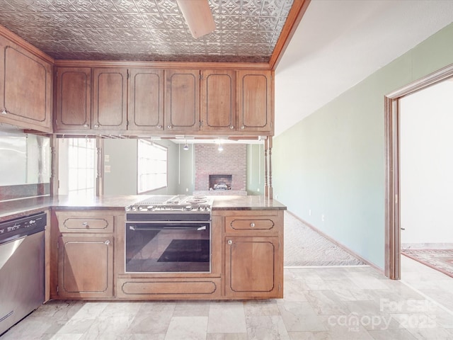 kitchen featuring an ornate ceiling, baseboards, appliances with stainless steel finishes, and a peninsula