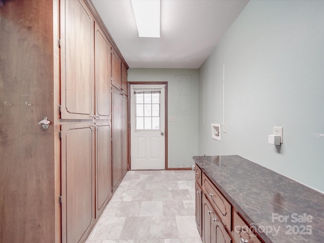 interior space with washer hookup, cabinet space, and baseboards