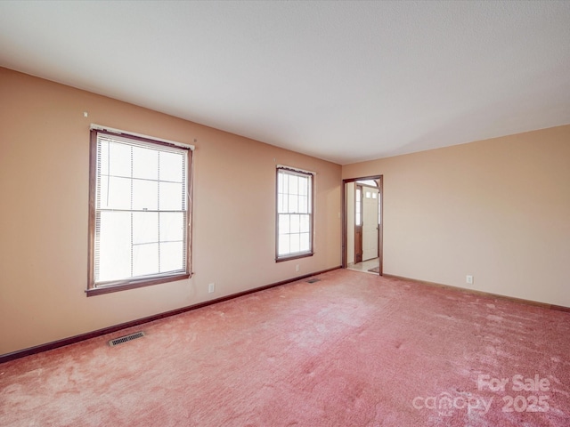 carpeted empty room featuring visible vents and baseboards