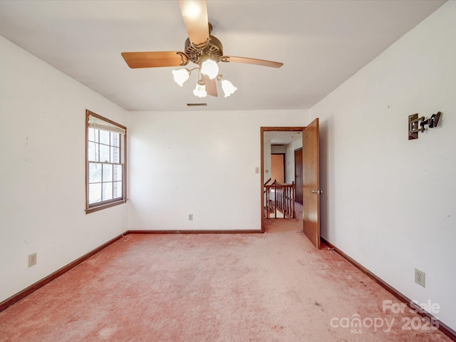 spare room with carpet floors, visible vents, and baseboards