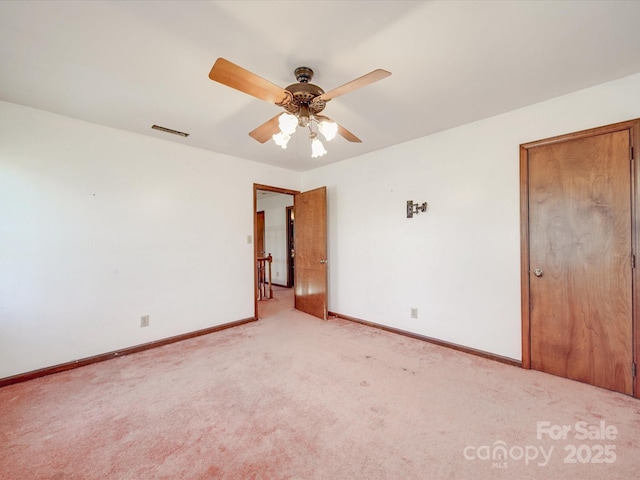 unfurnished room with light carpet, baseboards, visible vents, and a ceiling fan