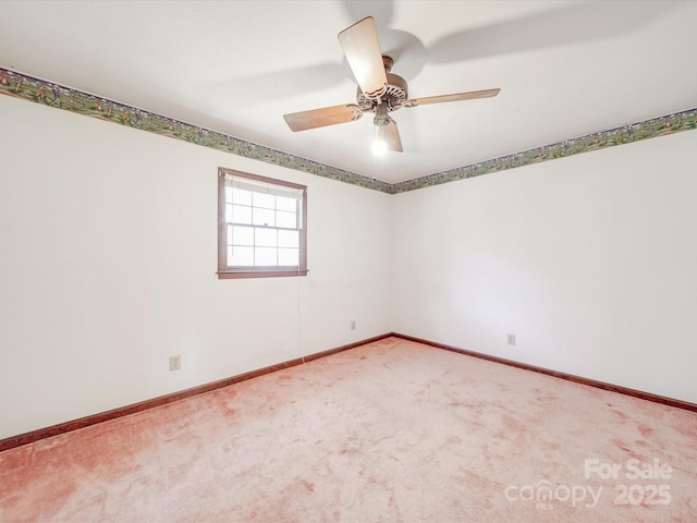 carpeted empty room with baseboards and a ceiling fan