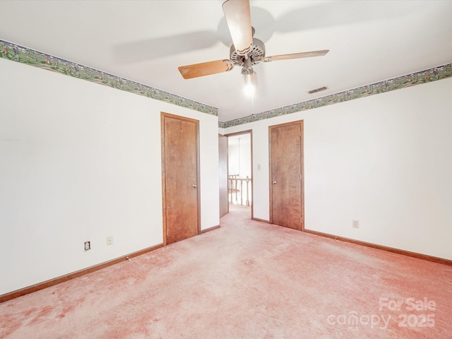 unfurnished room featuring carpet flooring, ceiling fan, visible vents, and baseboards