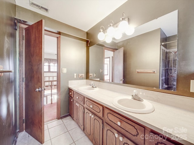 bathroom with double vanity, tile patterned flooring, visible vents, and a sink