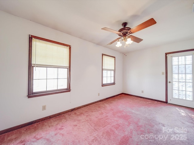 spare room with carpet, baseboards, and a ceiling fan