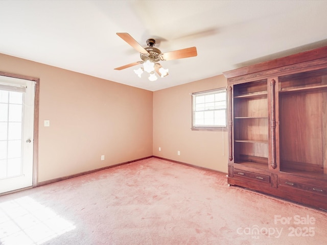 unfurnished bedroom with light carpet, baseboards, and a ceiling fan